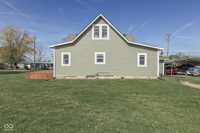 back of house featuring a yard and a detached carport