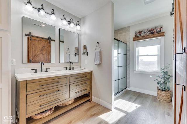 full bath featuring a sink, double vanity, wood finished floors, and visible vents