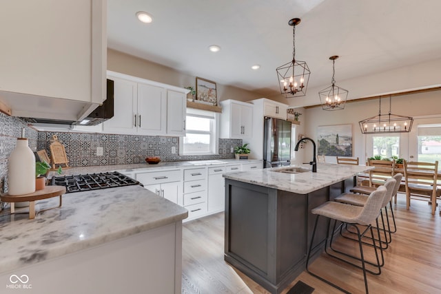 kitchen with freestanding refrigerator, a chandelier, a wealth of natural light, and a sink