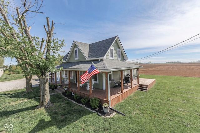 view of front of home featuring covered porch, a shingled roof, and a front lawn