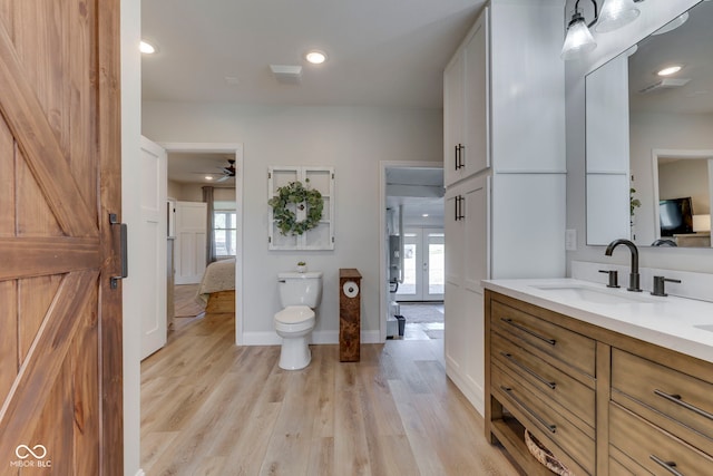 bathroom with ensuite bathroom, plenty of natural light, vanity, and ceiling fan