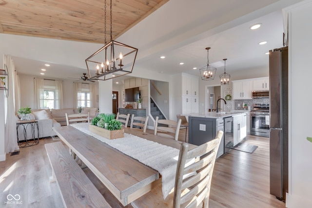 dining area with recessed lighting, stairs, light wood finished floors, and a chandelier