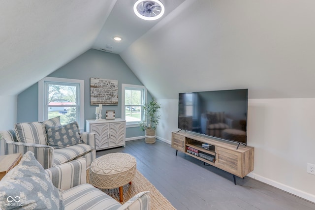 living area featuring baseboards, vaulted ceiling, and hardwood / wood-style flooring