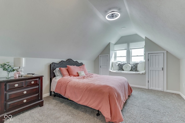 bedroom featuring light colored carpet, baseboards, and lofted ceiling