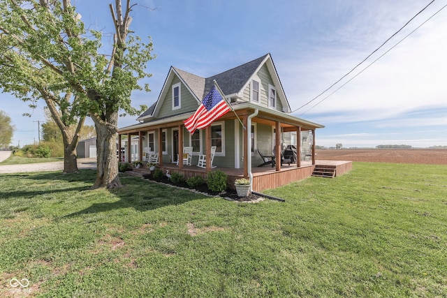 view of front of property featuring covered porch, a shingled roof, and a front yard