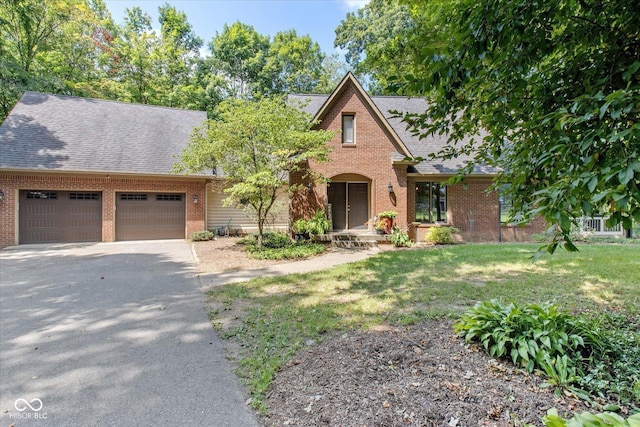 2450 S US-421, Zionsville, IN 46077 - tudor-style house featuring brick siding, a garage, and driveway