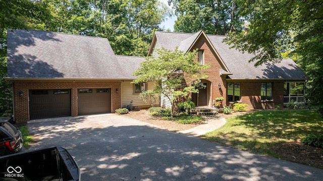 2450 S US-421, Zionsville, IN 46077 - view of front of house featuring driveway, a front yard, a garage, brick siding, and a shingled roof