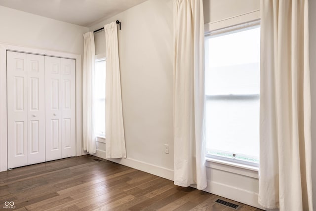 1451 N Grant Ave, Indianapolis, IN 46201 - unfurnished bedroom featuring dark wood-type flooring, a closet, and baseboards