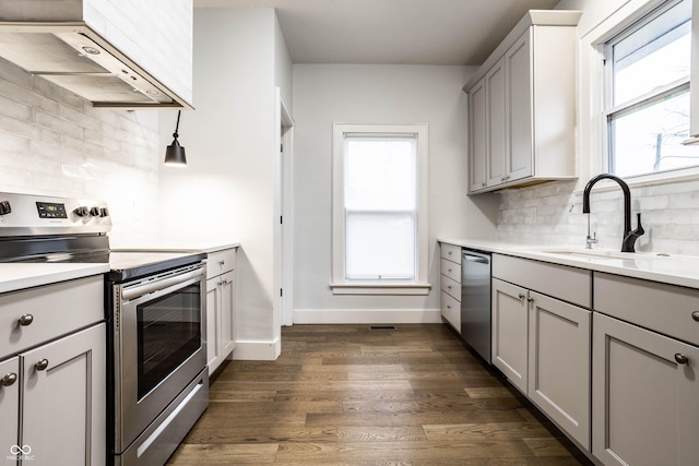 1451 N Grant Ave, Indianapolis, IN 46201 - kitchen featuring stainless steel appliances, extractor fan, gray cabinetry, a sink, and backsplash