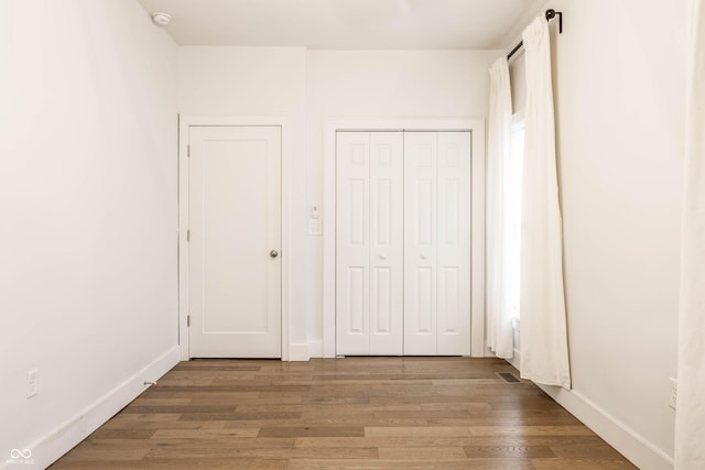 1451 N Grant Ave, Indianapolis, IN 46201 - unfurnished bedroom with wood finished floors, baseboards, and a closet