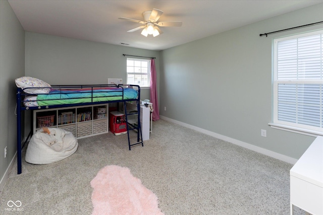carpeted bedroom featuring baseboards, visible vents, and ceiling fan