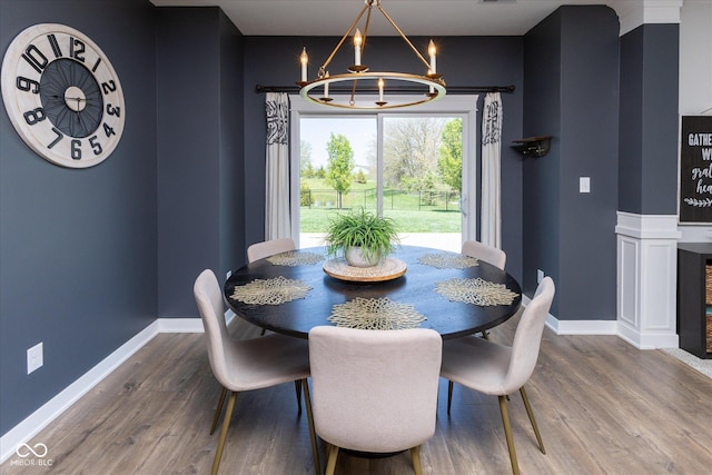 dining room featuring baseboards, wood finished floors, and a chandelier