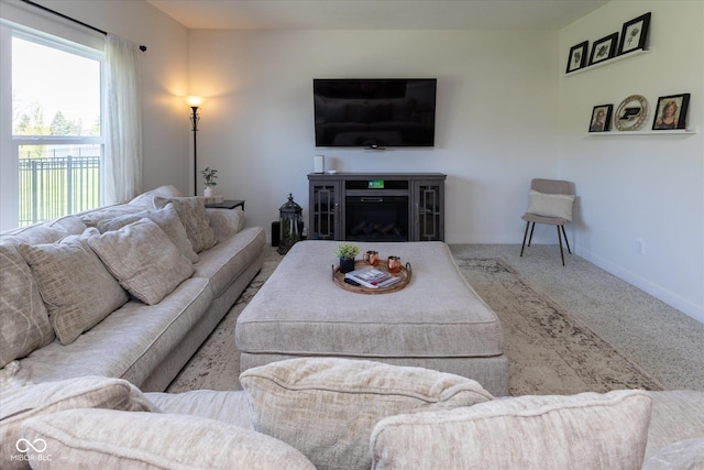 carpeted living area with baseboards and a fireplace