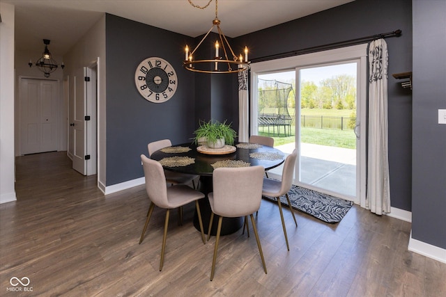 dining room with baseboards, a chandelier, and dark wood finished floors