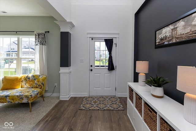 foyer entrance with plenty of natural light, dark wood-style flooring, visible vents, and decorative columns