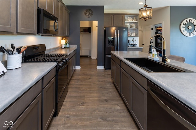 kitchen featuring open shelves, dark wood finished floors, a sink, light countertops, and black appliances