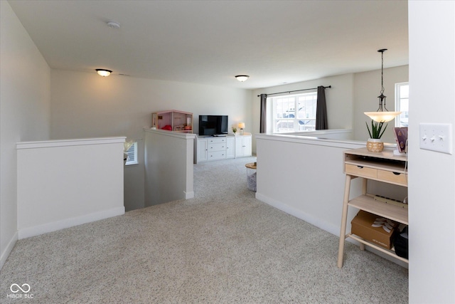 hall with a healthy amount of sunlight, baseboards, carpet flooring, and an upstairs landing