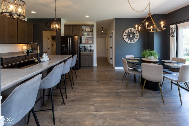 dining room with recessed lighting, dark wood finished floors, baseboards, and a chandelier