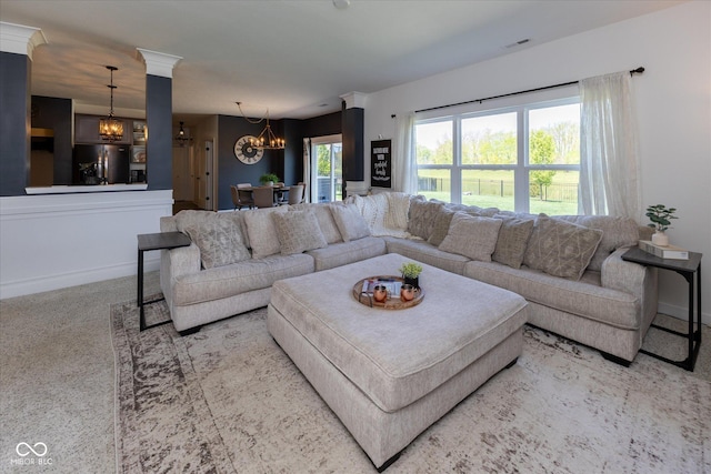 living area featuring visible vents, carpet flooring, baseboards, and a chandelier