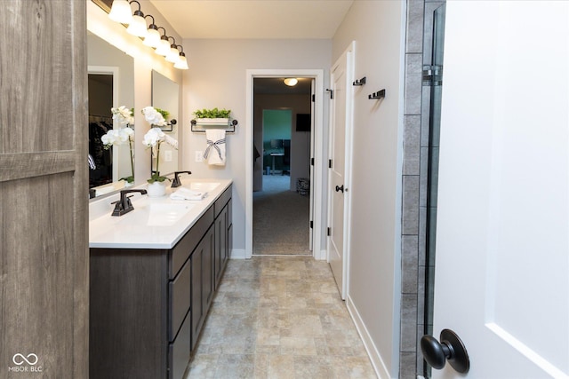 full bath featuring double vanity, a sink, baseboards, and stone finish floor