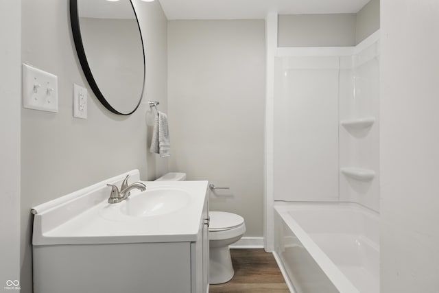 full bath with toilet, baseboards, wood finished floors, and vanity