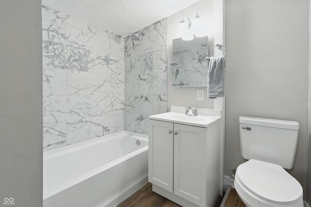 bathroom with vanity, toilet, wood finished floors, and shower / washtub combination