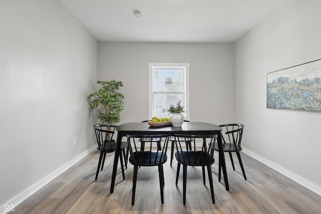 dining area with baseboards and wood finished floors