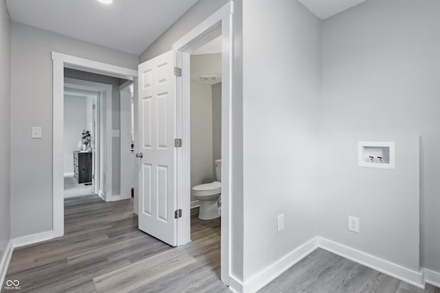 washroom with washer hookup, baseboards, laundry area, and wood finished floors