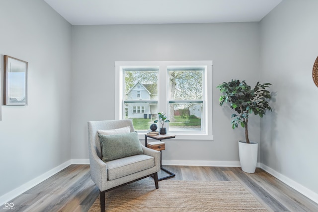 sitting room with baseboards and wood finished floors