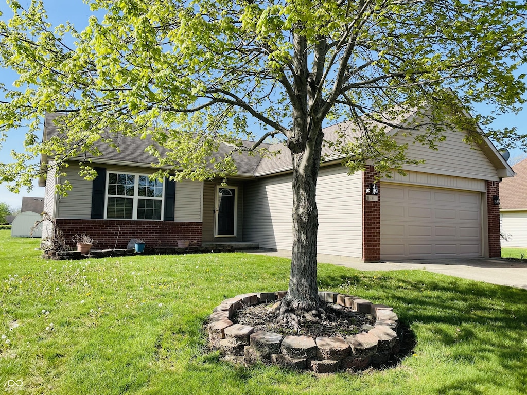 view of front facade with concrete driveway, brick siding, an attached garage, and a front lawn
