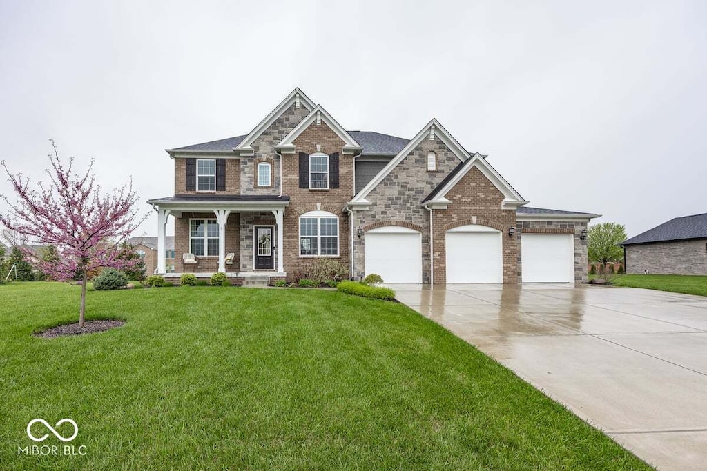 craftsman-style house with a garage, a front lawn, covered porch, brick siding, and concrete driveway
