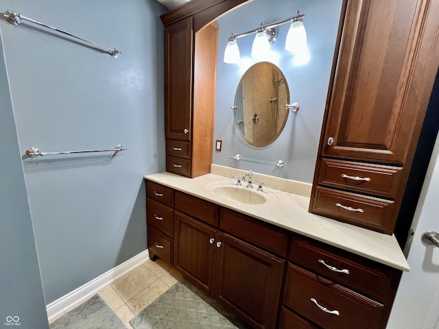 full bath with vanity, tile patterned flooring, and baseboards