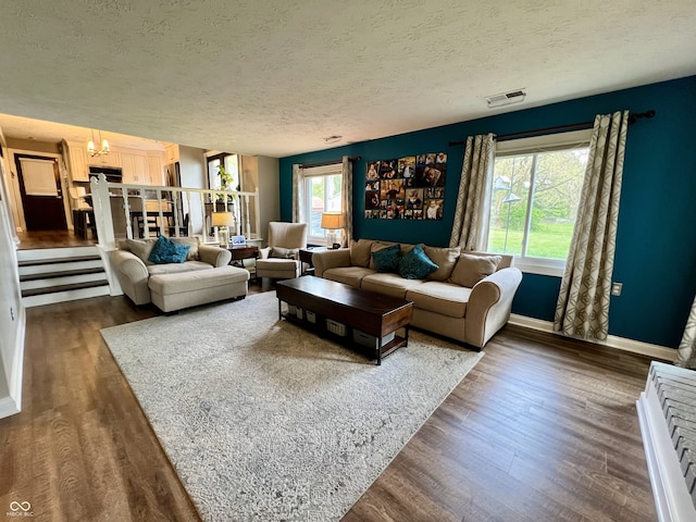living area featuring a textured ceiling, baseboards, and dark wood-type flooring