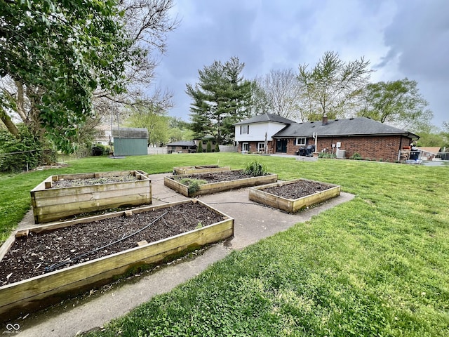 view of yard with an outdoor structure, a storage shed, and a vegetable garden