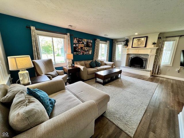 living area with a textured ceiling, dark wood-style floors, and a wealth of natural light