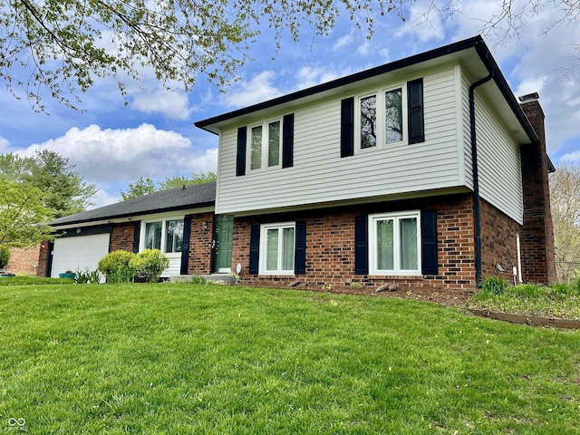 split level home with brick siding, a chimney, a front lawn, and a garage