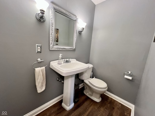 bathroom featuring baseboards, toilet, and wood finished floors