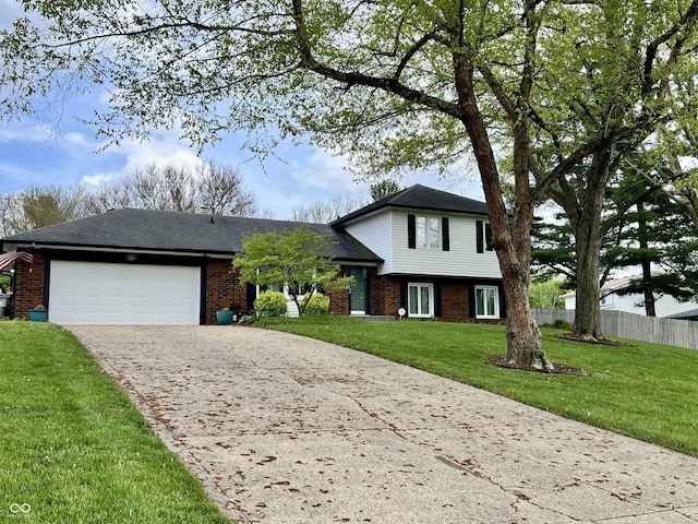 tri-level home featuring fence, a garage, driveway, and brick siding