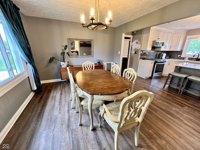 dining room with baseboards, a textured ceiling, a notable chandelier, and dark wood-style floors