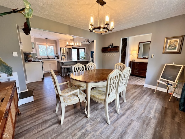 dining area with baseboards, a textured ceiling, and dark wood-style floors