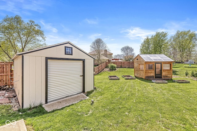 view of yard featuring a fire pit, an outbuilding, a fenced backyard, and a shed