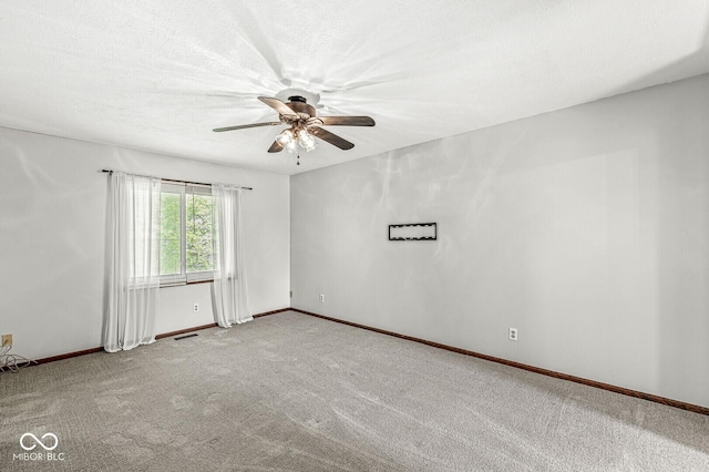 empty room with carpet floors, ceiling fan, and baseboards
