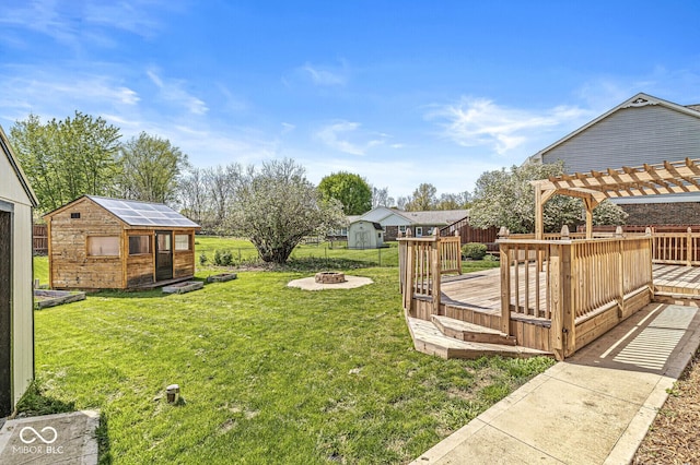 view of yard featuring a pergola, an outdoor structure, an outdoor fire pit, and a deck