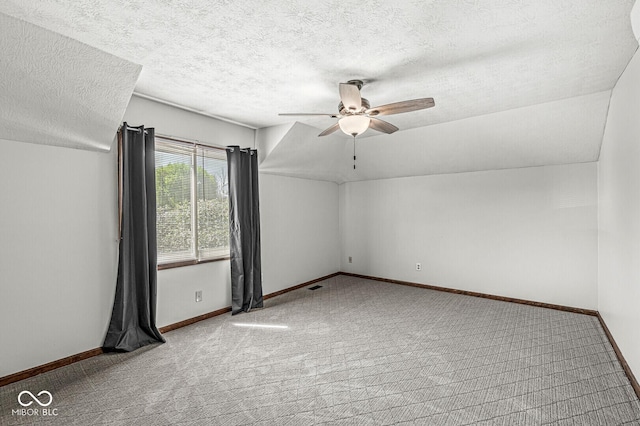 spare room featuring carpet floors, a textured ceiling, a ceiling fan, baseboards, and visible vents