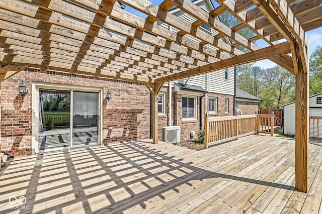 wooden deck with a storage unit, an outdoor structure, ac unit, and a pergola