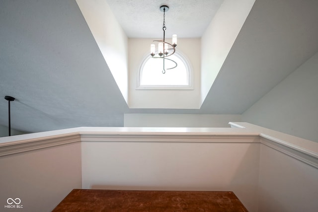 staircase featuring a textured ceiling and a notable chandelier