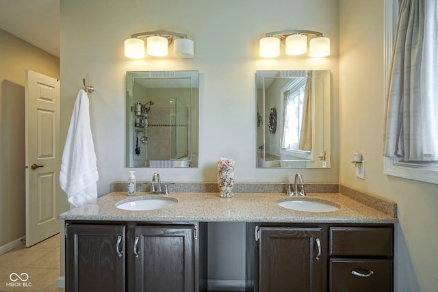 full bath featuring double vanity, tile patterned floors, a shower stall, and a sink