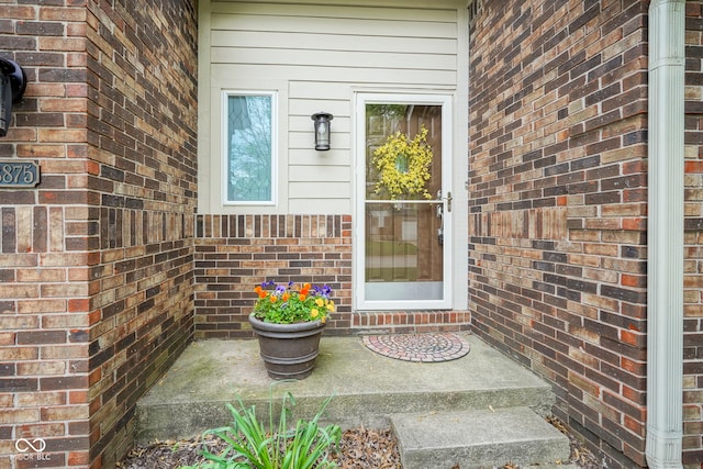 doorway to property with brick siding