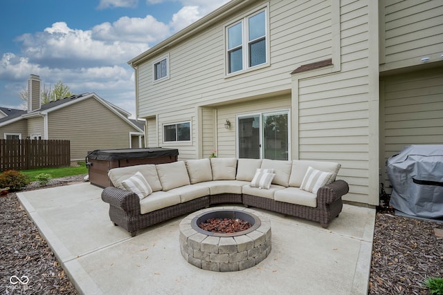 view of patio with grilling area, fence, a hot tub, and an outdoor fire pit