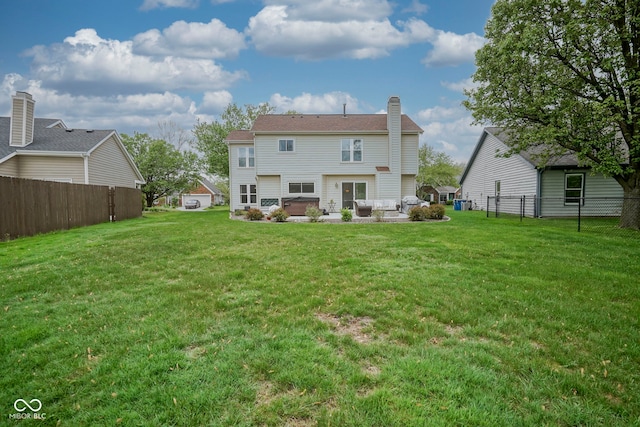 rear view of house with a lawn, fence, and a chimney
